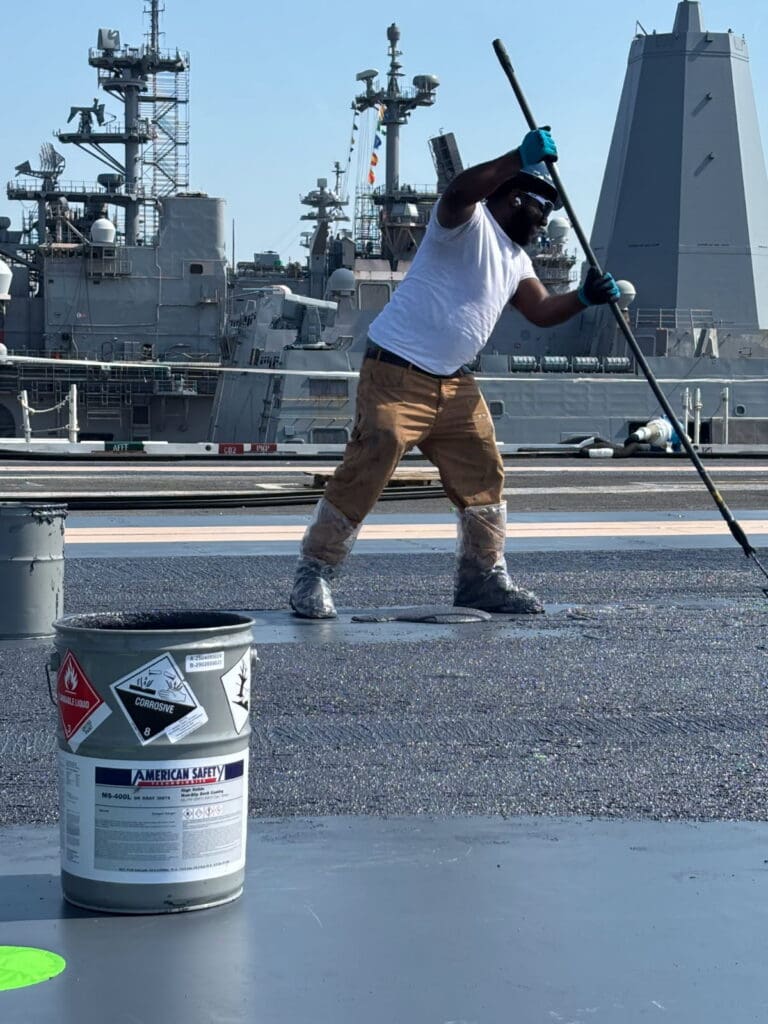 Contractor applying MS-400L non-skid coating on USS aircraft carrier flight deck